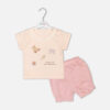 Baby girls peach short-sleeve t-shirt with eyelet lace collar and teddy bear print paired with pink ruffled shorts from Mini & Me.