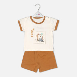 Toddler boy 2-piece summer clothing set featuring an off-white t-shirt with a "Lucky" cartoon toast graphic and tan trim details, paired with matching tan elasticated shorts from Mini & Me.