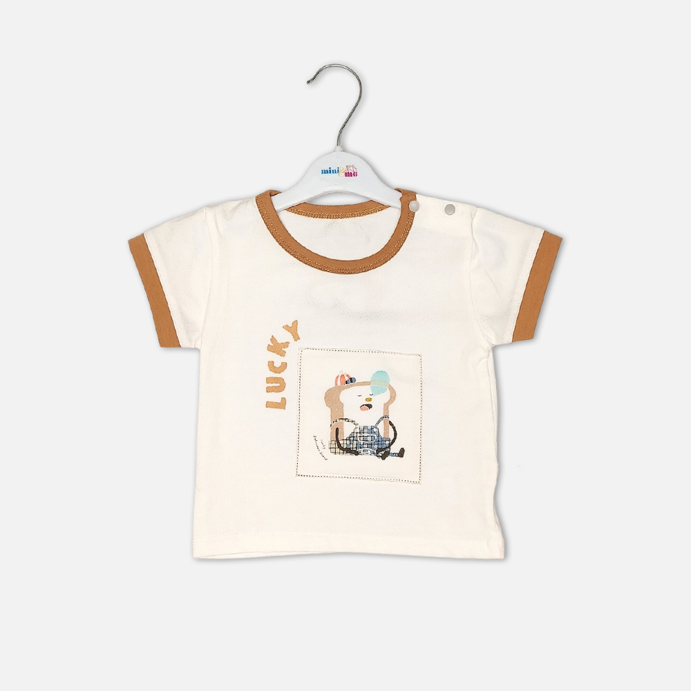 boysSuit14172-1-3 Toddler boy 2-piece summer clothing set featuring an off-white t-shirt with a "Lucky" cartoon toast graphic and tan trim details, paired with matching tan elasticated shorts from Mini & Me.