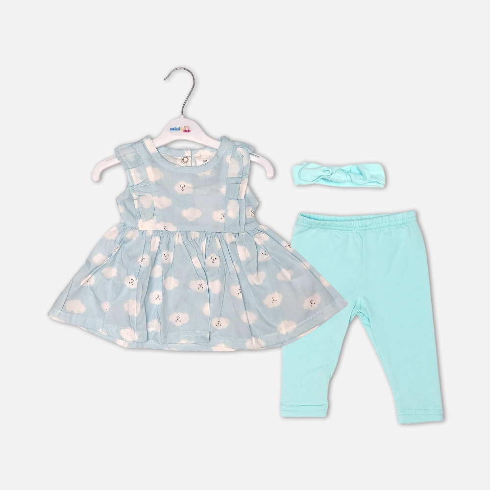 girlsSuit13127-1 Baby girl 3-piece summer clothing set showcasing a sleeveless sky blue frock with a white smiling cartoon cloud print and shoulder ruffles, displayed alongside matching mint green leggings and a knotted bow headband from Mini & Me.