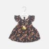 Mini and Me baby girl black cotton frock with peach floral print, flutter sleeves, and 3D flower detail on waist hanging on a white hanger