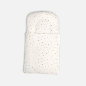 Premium cotton baby carry nest from Mini & Me in an off-white cream color, detailed with a subtle scattered print of tiny pink flowers and minimalist leaves across both the headrest pillow and the lower swaddle blanket layer.