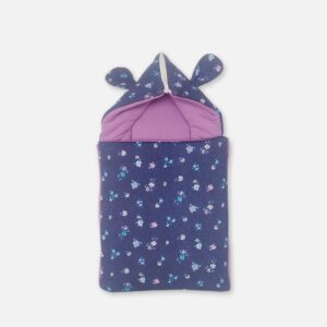 A premium newborn convertible carry nest sleeping bag featuring a navy blue exterior print with tiny pink and purple flowers, a soft lilac purple cushioned interior, and a convertible zippered hood accented with cute matching floral 3D ears.