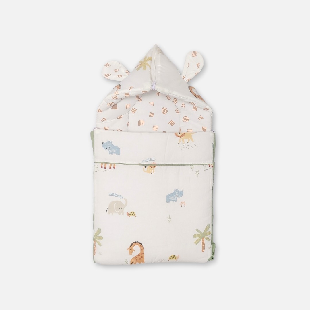 20260711_171527 (9) A convertible cream-colored baby carry nest featuring a pastel safari animal print with elephants, giraffes, and lions, showing both the open rectangular bedding layout and the zipped hooded setup with fabric ears.