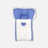 White baby carry nest and sleeping bag decorated with pastel blue and yellow star prints, featuring a solid blue cushioned headrest, ruffle-trim hood, and a decorative blue bow.