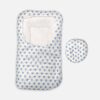 White baby swaddle wrap and sleeping pod featuring an all-over blue heart print pattern, a cushioned headrest section, and an adjustable wrap-around flap.