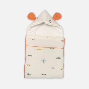 A premium convertible cream-colored baby carry nest with a terracotta trim and backing, featuring a minimalist scattered print of blue airplanes, grey helicopters, and small cars across the lower blanket section.
