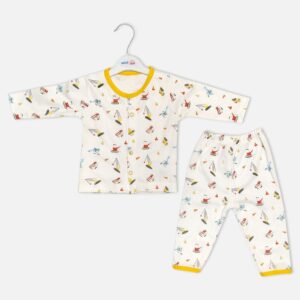 Unisex white cotton baby nightwear set from Mini and Me featuring a long-sleeve button-up top and matching pants with a colorful construction vehicle pattern and bright yellow trim.