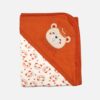 A folded orange and off-white hooded baby blanket featuring a repeating panda face and star pattern on the body, with a solid orange hood detailed with an embroidered bear head and the text "BE HAPPY."