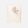 A folded off-white 100% cotton hooded baby blanket featuring an embroidered pink caravan, a small pink car with a dog, and a tree on the corner hood section, displayed over a clean background.