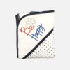 A folded cotton hooded baby blanket featuring a clean white corner hood with embroidered stars and Be Happy text details, alongside a white fabric body decorated with a navy blue polka dot pattern.
