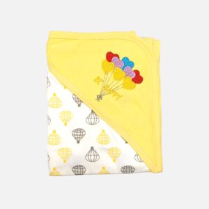 A folded yellow and off-white hooded baby blanket featuring a repeating hot air balloon print on the body, with a solid yellow hood detailed with a colorful embroidered bunch of heart balloons and the text "BE HAPPY."