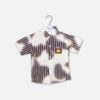 Boys short-sleeve button-down shirt featuring a dark brown vertical stripe and white tie-dye cloud pattern with a brown rectangular chest patch hanging on a branded hanger.
