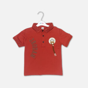 A premium rust red boys polo collar t-shirt with short sleeves, a three-button placket, embossed side lettering, and a round fashion patch with hanging accent cords, displayed on a hanger.