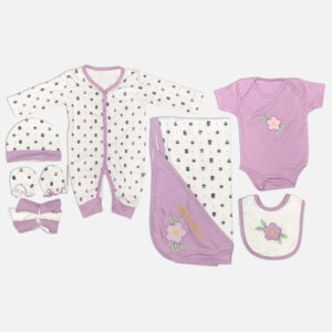 Seven piece lavender floral cotton baby clothing set including sleepsuit bodysuit blanket bib cap and mittens arranged on a plain background