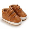Tan faux leather baby high-top sneakers with dual velcro straps, perforated toe details, and white soft soles from Mini and Me.
