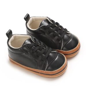 Pair of black leather baby sneakers with black laces, a soft cream interior, and a tan rubber-look sole with a black stripe accent.
