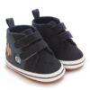 Pair of dark navy corduroy and leather-style high-top baby sneakers featuring dual hook-and-loop straps, embroidered tractor and snail illustrations on the side, a white sole border, and a textured non-slip outsole.