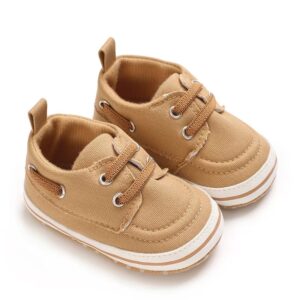 Pair of tan canvas baby boat shoes with matching tan elastic laces, silver-tone metal eyelets, a white sole border with a tan stripe, and a canvas heel pull tab.