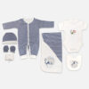 A 7-piece newborn baby starter layette set laid out on a gray background, featuring a dark navy and white striped long-sleeve snap romper, a matching striped beanie hat, striped mittens, a rolled white washcloth, a white short-sleeve bodysuit with fish embroidery, a matching hooded blanket, and a feeding bib.