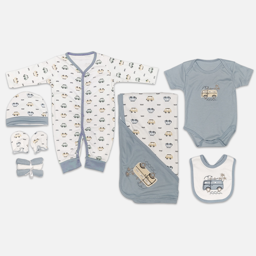StarterSet3-1 A 7-piece newborn baby starter layette set laid out on a gray background, featuring a white long-sleeve snap romper with a vintage car print, a matching beanie hat, mittens, a rolled white washcloth, a solid blue-gray short-sleeve bodysuit with camper van embroidery, a matching hooded blanket, and a feeding bib.