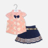 A luxury two-piece baby girls clothing set featuring a short-sleeve peach button-down shirt with embroidered flowers, sequin details, and a navy blue bow tie, alongside a pleated navy blue skirt with horizontal metallic stripes and a gold belt, displayed on a hanger.