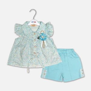 A premium two-piece summer clothing set for baby girls featuring a light blue button-down blouse with an all-over ditsy floral print, ruffle sleeves, and a matching blue fabric flower brooch, alongside sky blue shorts with matching floral side panels, displayed on a hanger.