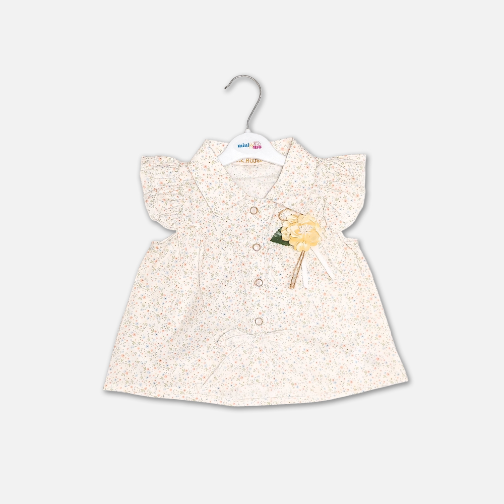 girlsSuit13134-2-3 A premium two-piece summer clothing set for baby girls featuring a cream button-down blouse with an all-over ditsy floral print, ruffle sleeves, and a yellow fabric flower brooch, alongside pastel yellow shorts with matching floral side panels, displayed on a hanger.