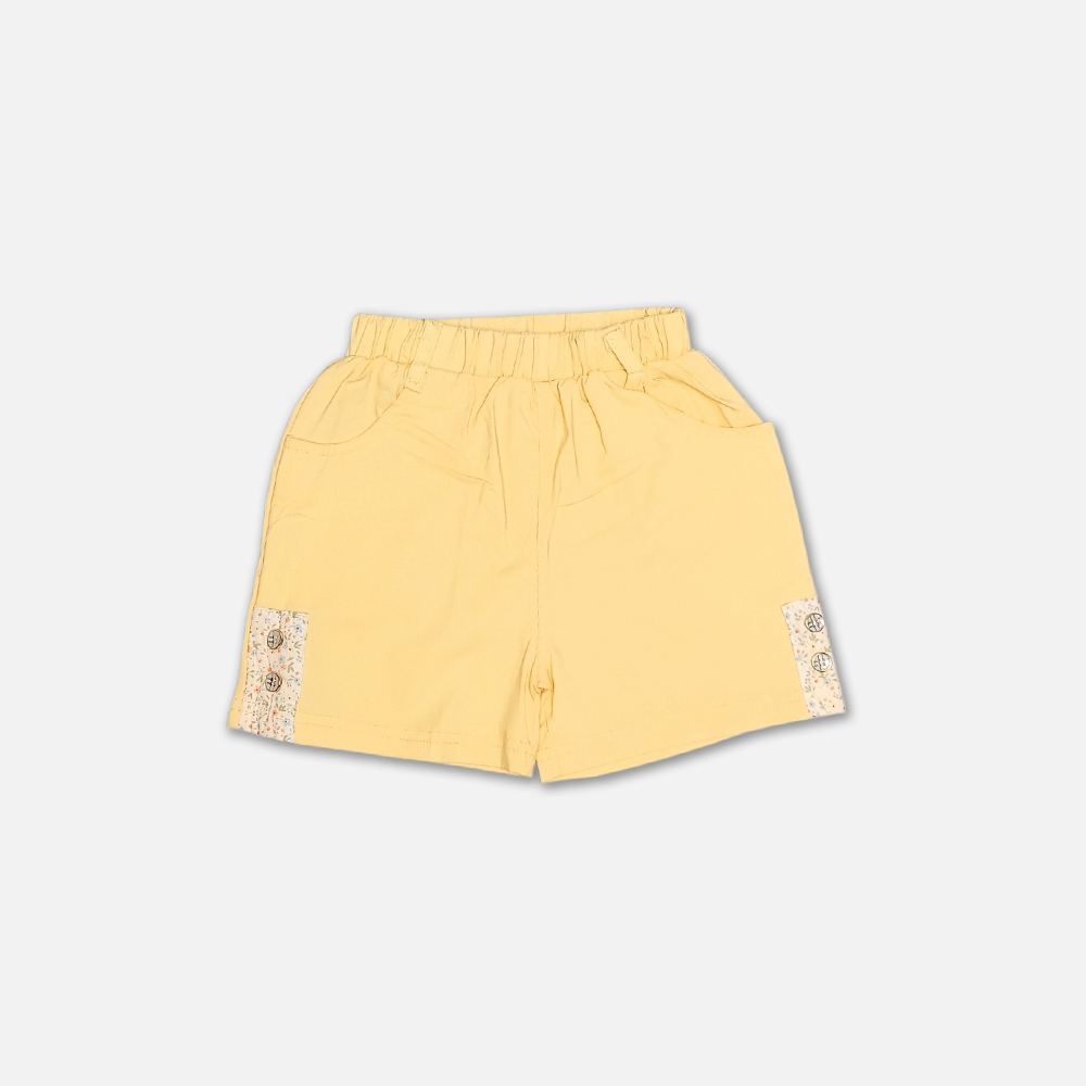 girlsSuit13134-2-4 A premium two-piece summer clothing set for baby girls featuring a cream button-down blouse with an all-over ditsy floral print, ruffle sleeves, and a yellow fabric flower brooch, alongside pastel yellow shorts with matching floral side panels, displayed on a hanger.