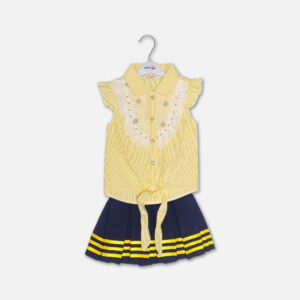 A premium two-piece summer outfit for baby girls consisting of a yellow and white pinstriped button-down blouse with a white lace embroidered bib and tie-front knot, paired with a pleated navy blue skirt featuring horizontal yellow stripes and a metallic gold belt, shown on a white hanger.