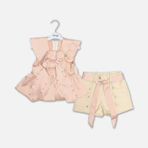 A premium two-piece formal clothing set for baby girls featuring a sleeveless peach-colored satin peplum top with a structured collar, rhinestone embellishments, and a fabric flower brooch, paired with beige shorts featuring rhinestone accents and a matching peach ribbon waist tie, displayed on a white hanger.