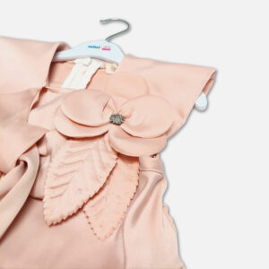 A premium two-piece formal clothing set for baby girls featuring a sleeveless peach-colored satin peplum top with a structured collar, rhinestone embellishments, and a fabric flower brooch, paired with beige shorts featuring rhinestone accents and a matching peach ribbon waist tie, displayed on a white hanger.