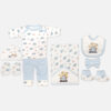 Mini & Me 7-piece light blue and white newborn baby boy layette set featuring car print and teddy bear driver illustration including top, pants, hooded blanket, bib, cap, mittens, and booties